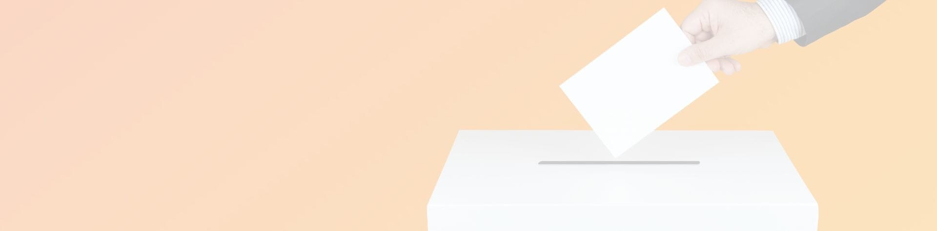 an arm dropping a ballot into a voting box