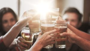 group drinking and cheering pints of beer