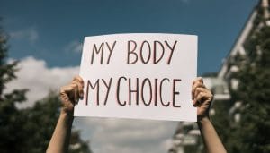 Hands holding a sign in the air that reads