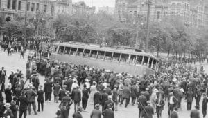 Old image of the 1919 Winnipeg General Strike where women and men overturned a street car