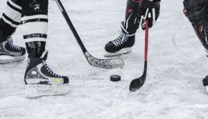Skates of two hockey players facing off at puck drop